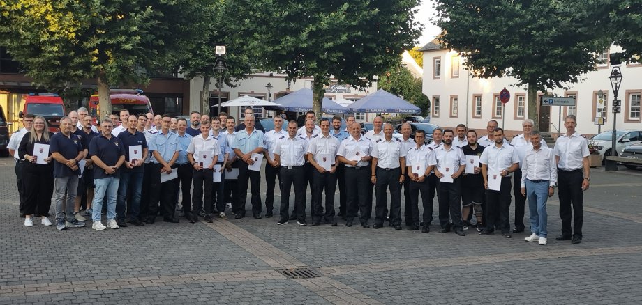 Feierwehrfrauen und -männer stehen zusammen bei der Verleihung des bronze und silbernen Ehrenzeichens