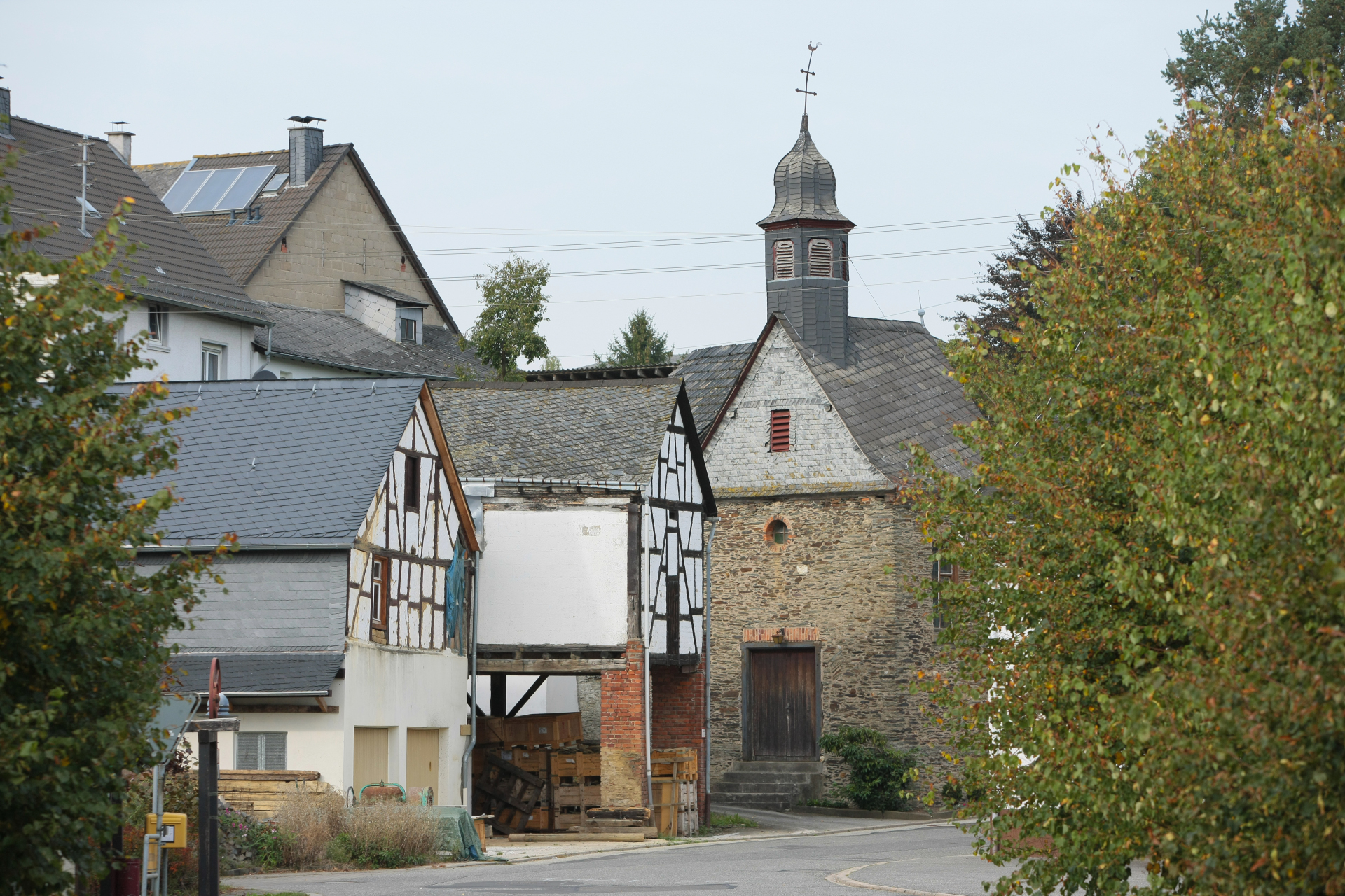 Fachwerkhäuser von Belgweiler mit der Kirche im Hintergrund bei trübem Wetter