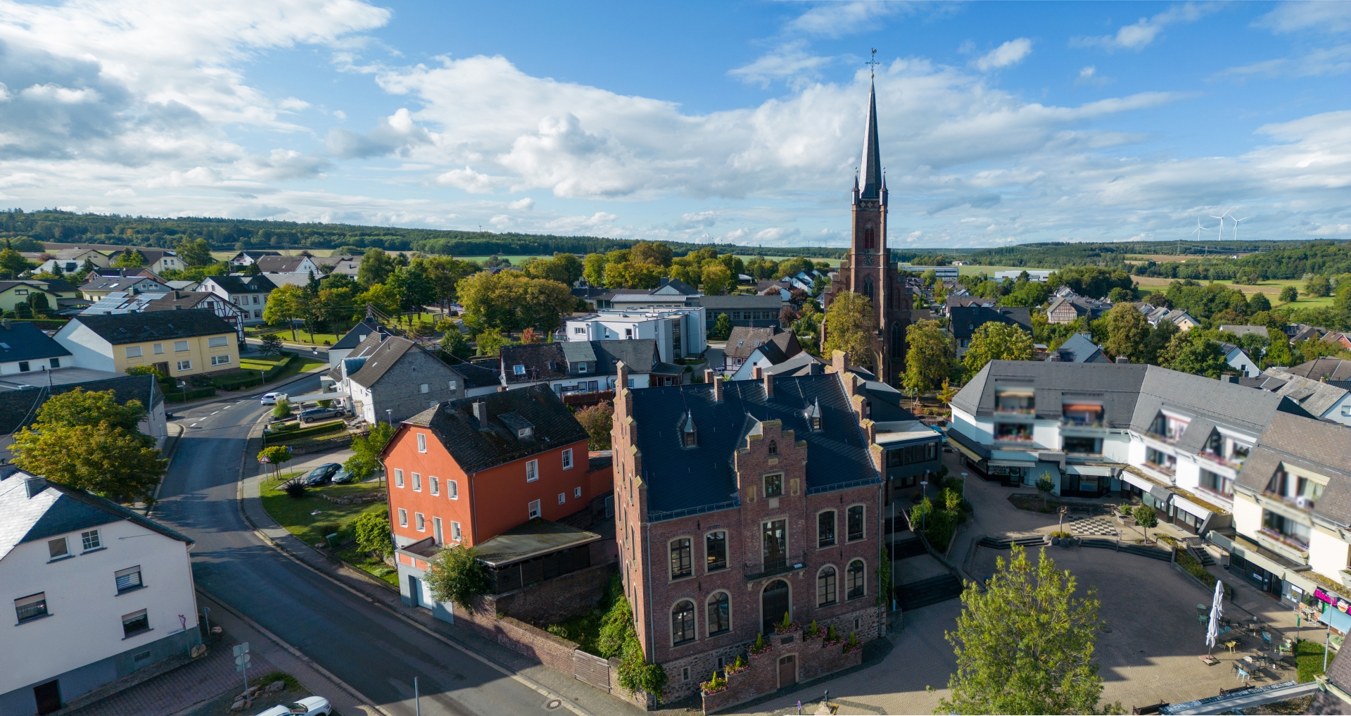 Rathaus und Marktplatz im Vordergrund mit Blick auf die Kirche bei schönem Wetter