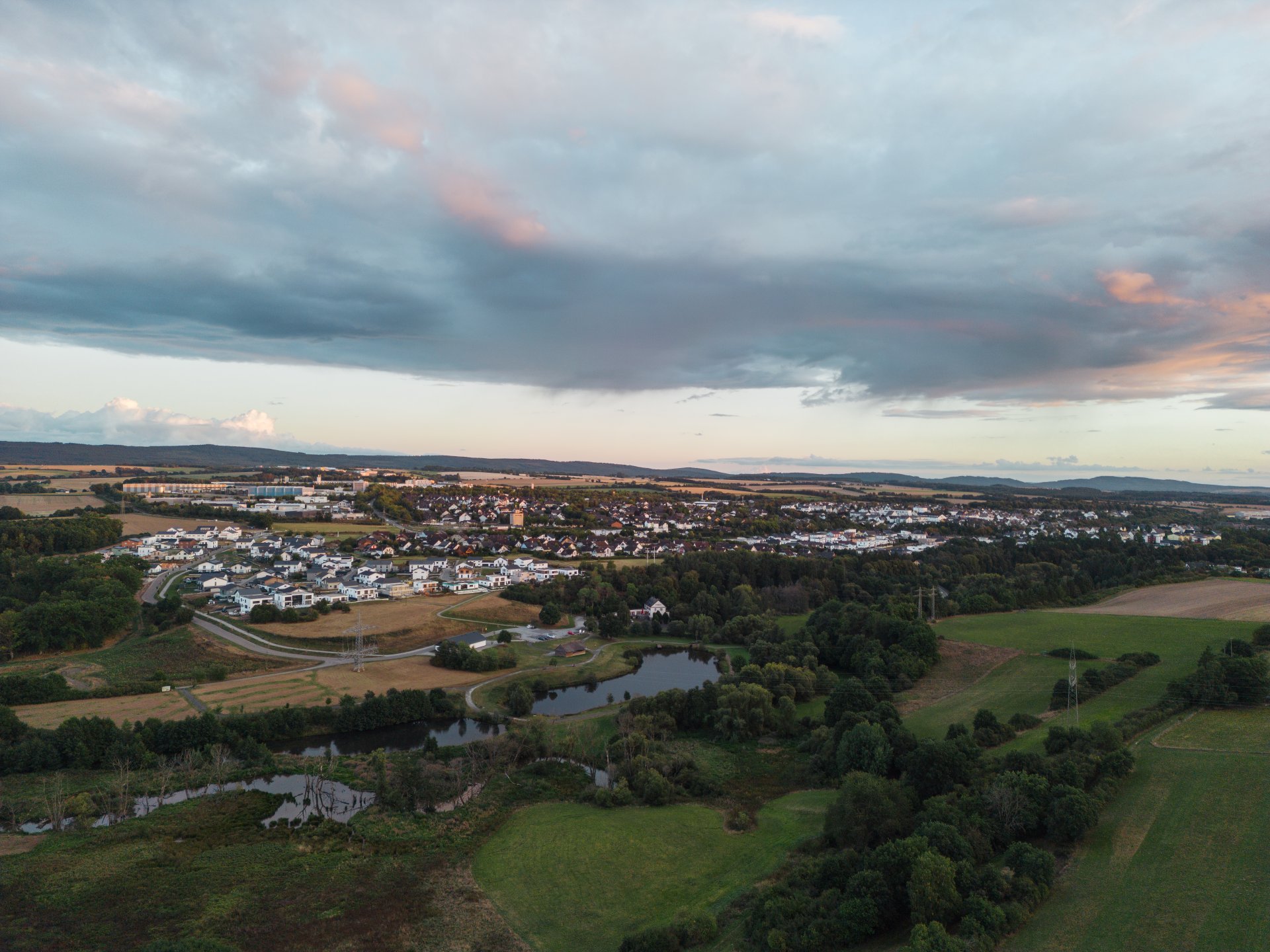 Drohnenaufnahme vom Simmersee und der Stadt Simmern im Hunsrück bei Sonnenuntergang