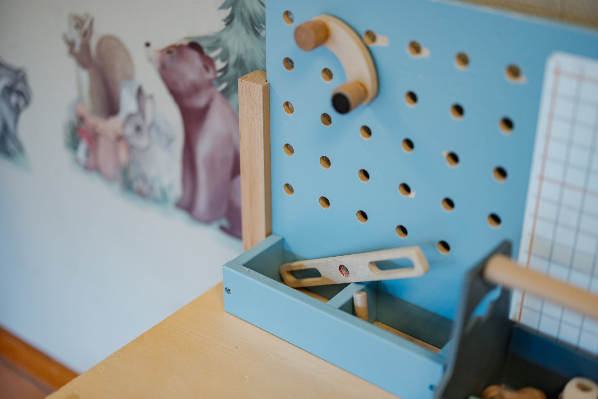 Kinderwerkbank mit bunter Tapete im Hintergrund