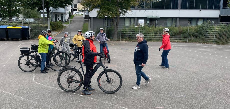 Seniorinnen und Senioren üben E-Bike fahren auf dem Schulhof der Rottmannschule