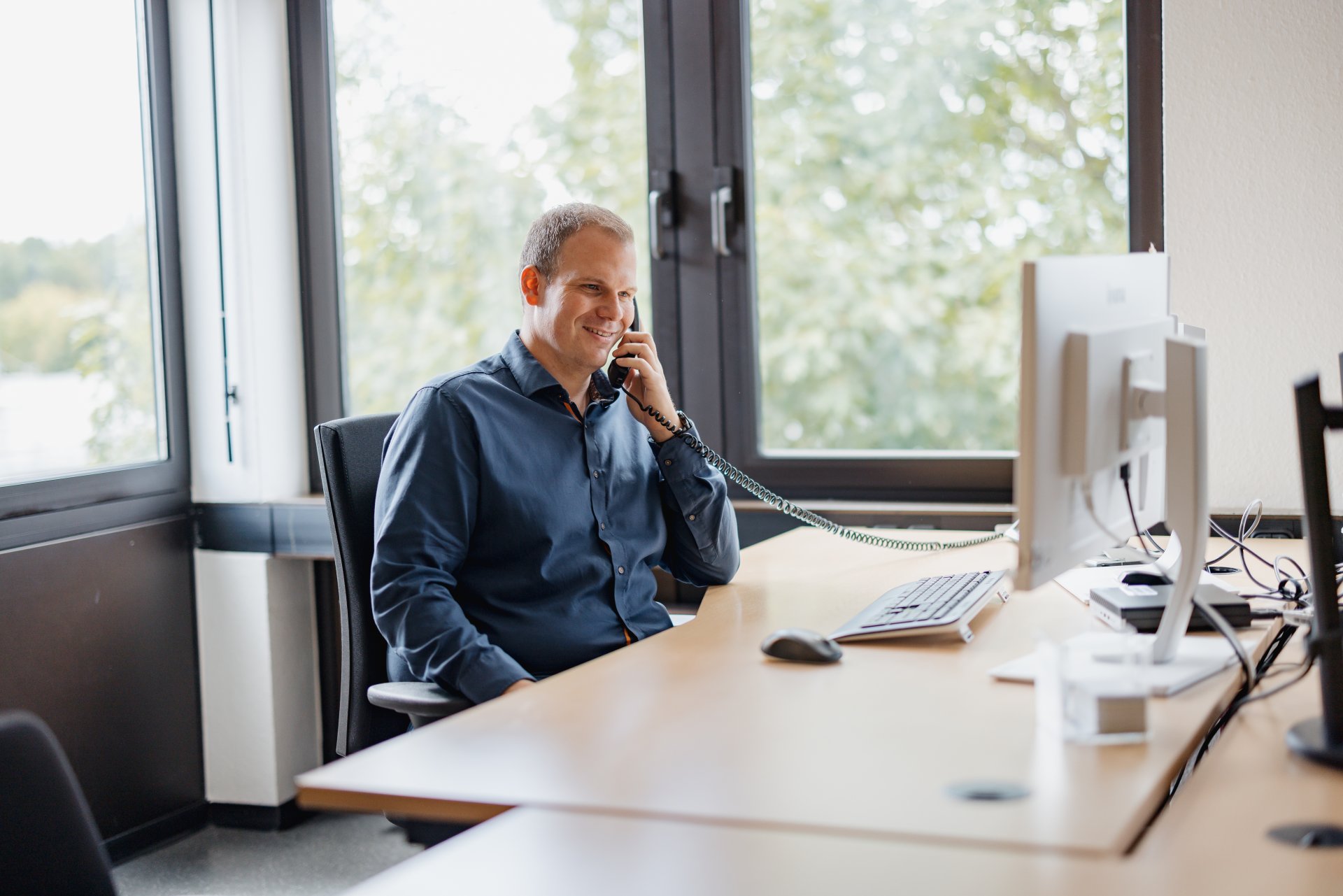 Person sitzt an seinem Schreibtisch und arbeitet.