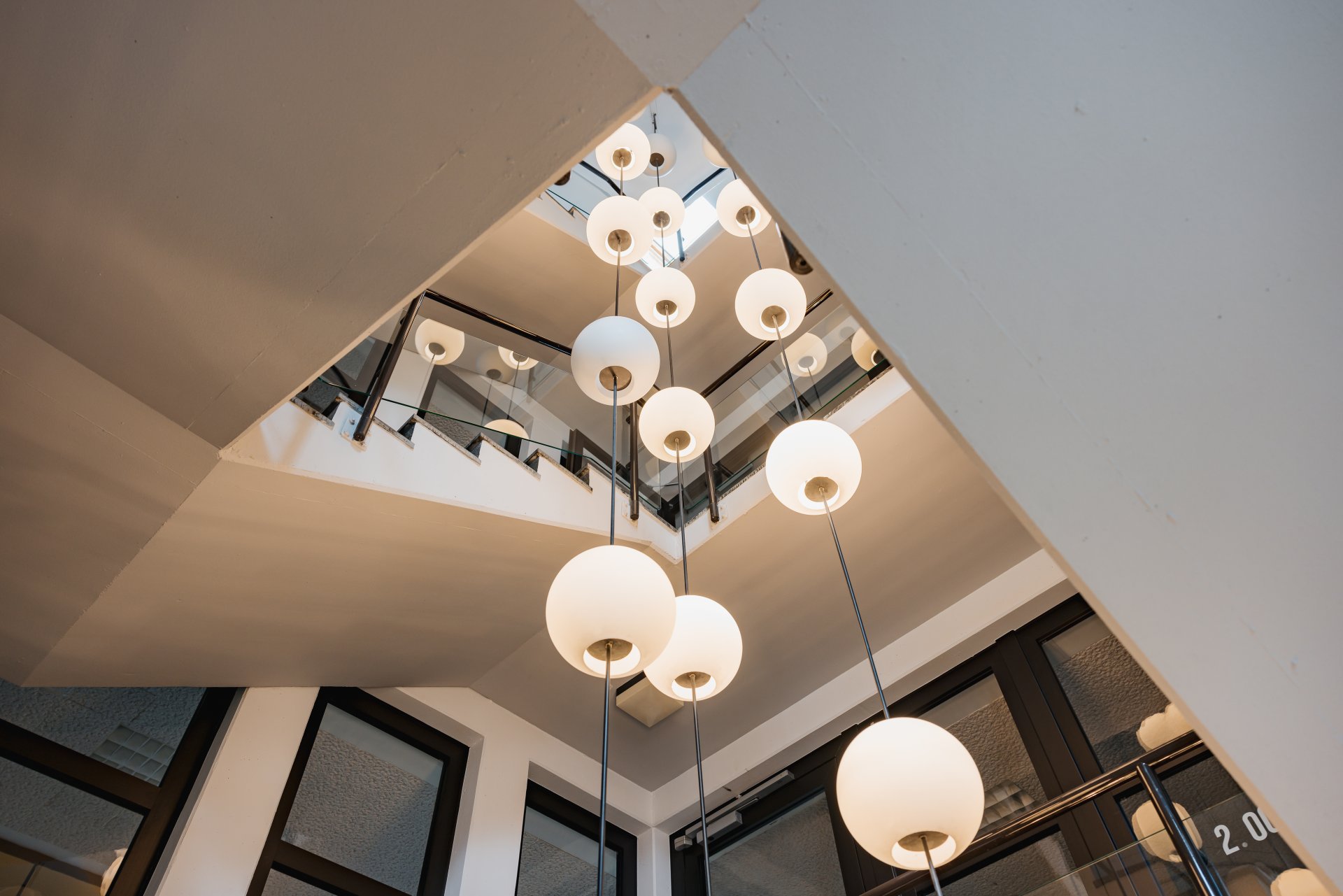 Blick auf das Treppenhaus im Rathaus Simmern mit vielen Leuchten an der Decke