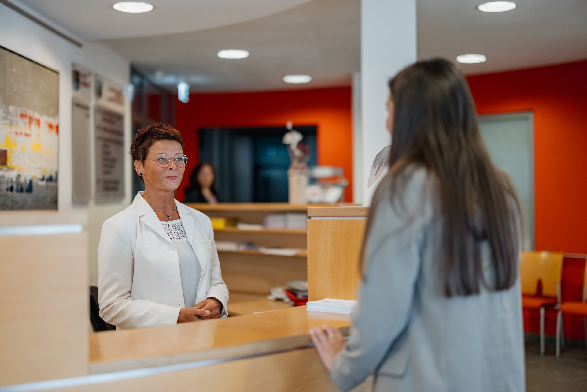 Zwei Mitarbeiter im Flur des Bürgerbüros vor der Infothek