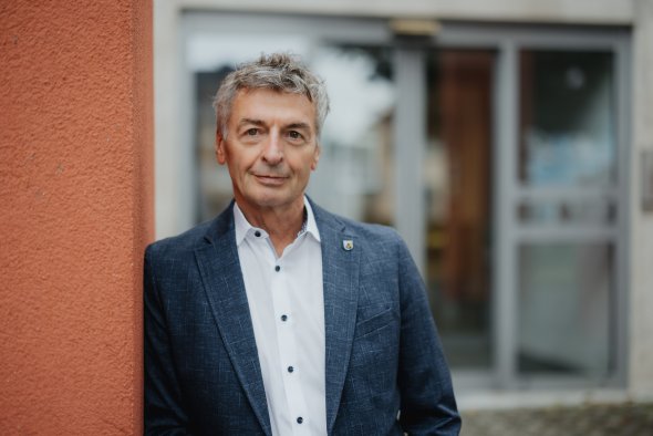 Ein Portrait von dem Verbandsbürgermeister Michael Boos, der am Eingang des Rathauses in Simmern steht
