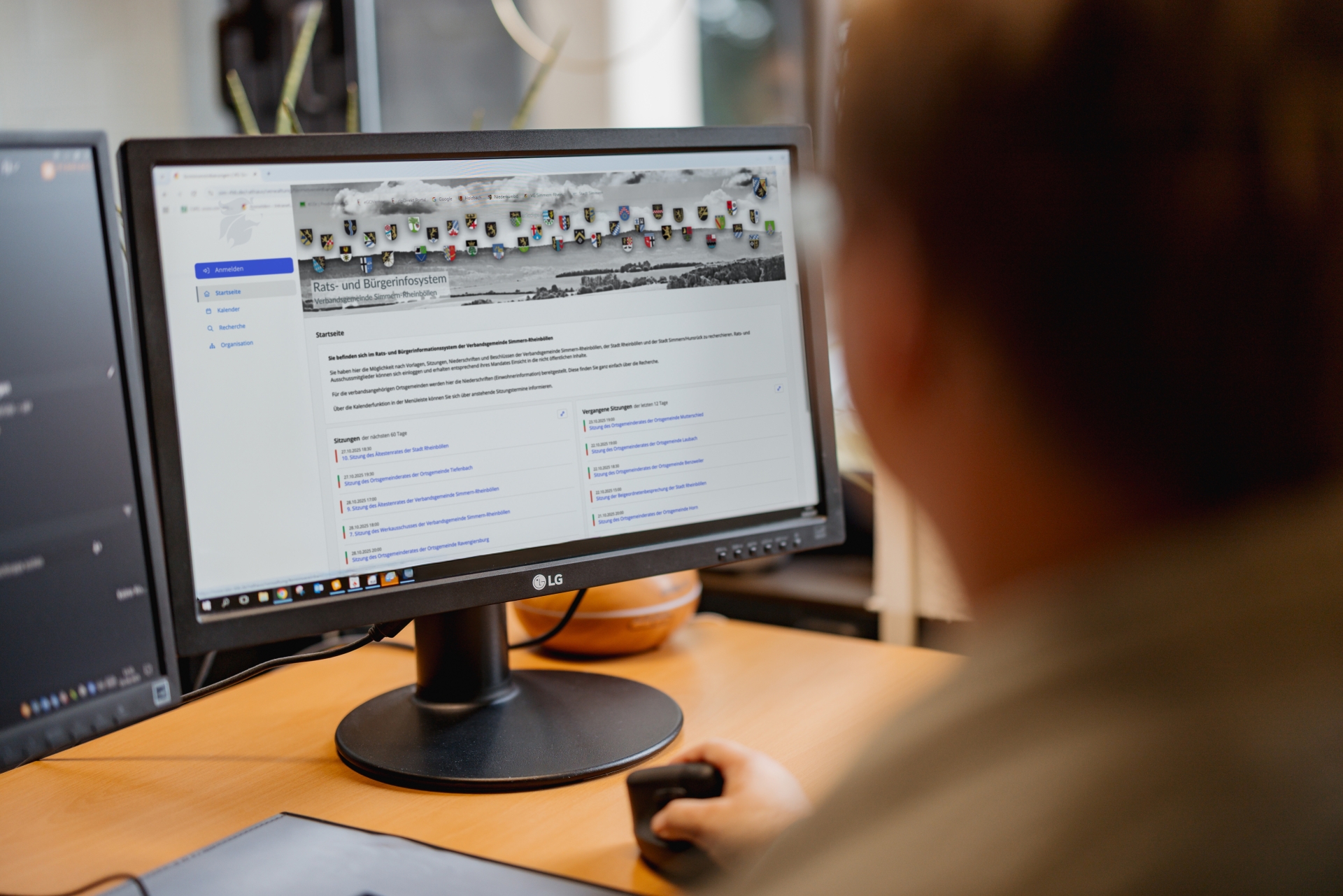 Person sitzt vor dem Bildschirm und schaut auf das Rats- und Bürgerinfosystem.