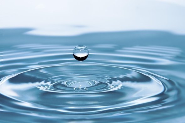 Wassertropfen, der aufs Wasser fällt.