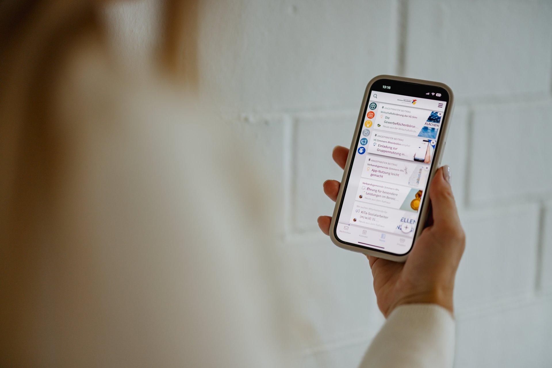 Frau guckt auf ihr Handy, auf dem die Communi App geöffnet ist.