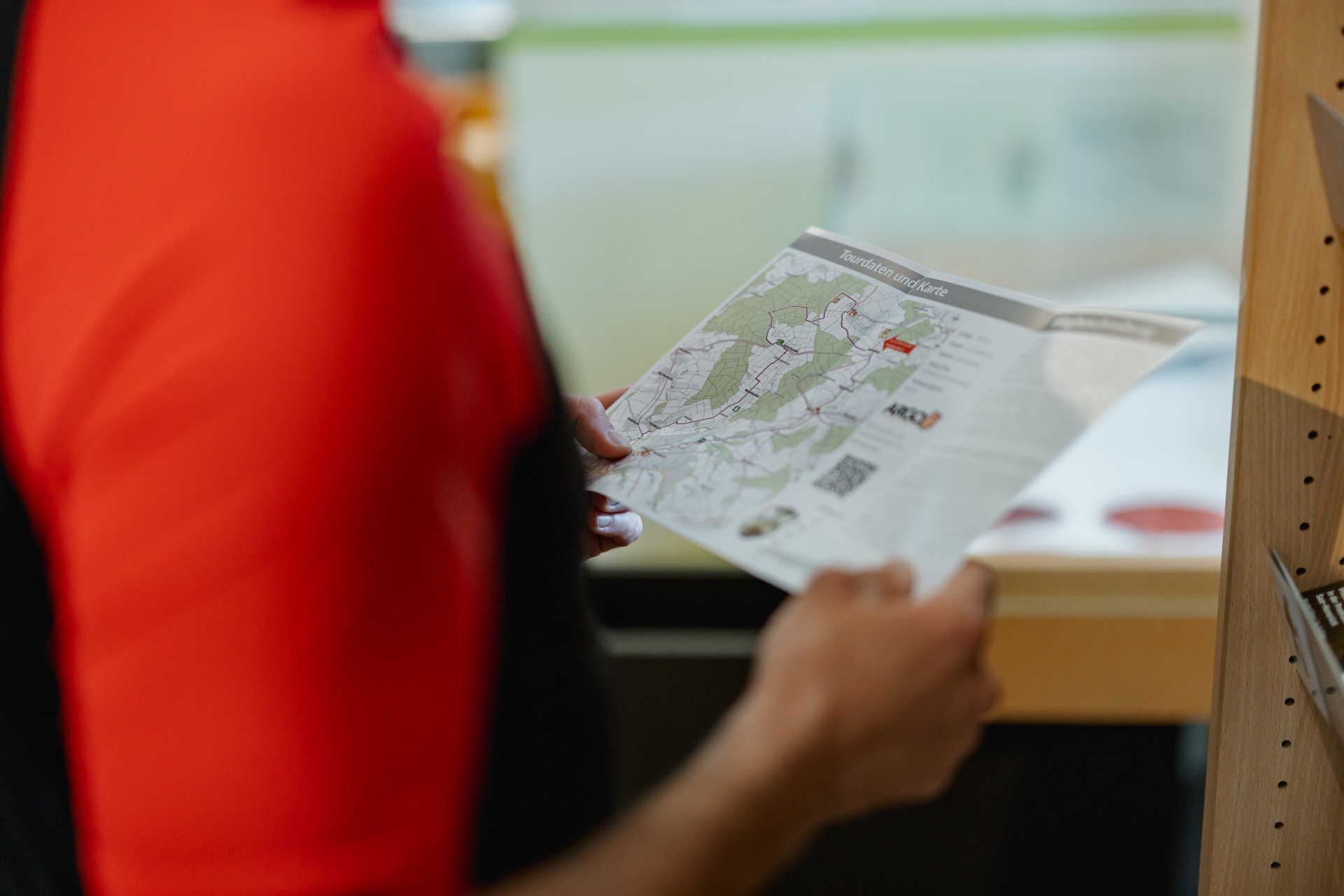 Radfahrer betrachtet ein Prospekt in der Tourist-Information in Simmern