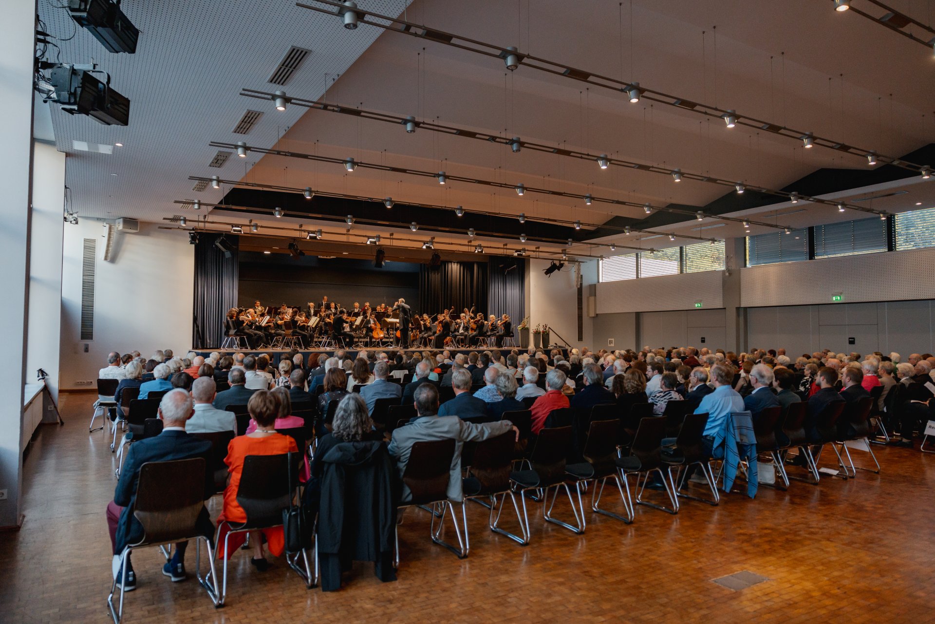 Konzert der Harmonie mit vielen Besuchern und einer Band auf der Bühne